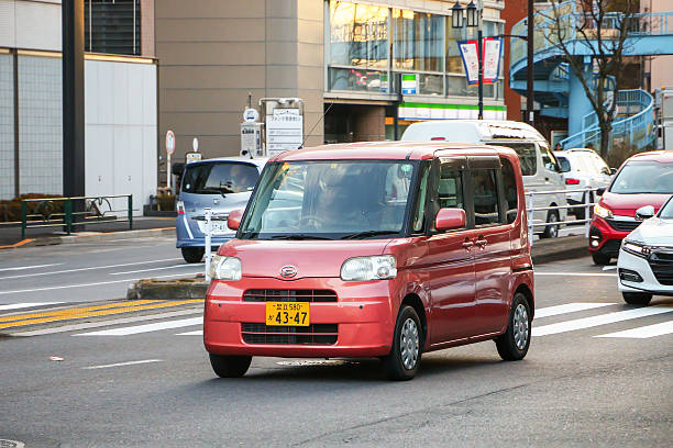 Tokyo, Japan - January 14, 2025: Pink urban car Daihatsu Tanto (L375) in the city street.