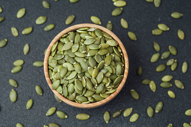 istock Pumpkin seeds in wooden bowl 2221807947