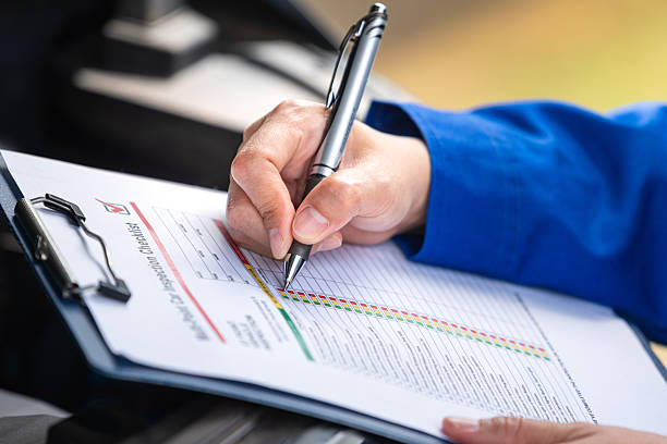 istock Repairman is checking on multi-point checklist form during perform service the car parts. 2221810567