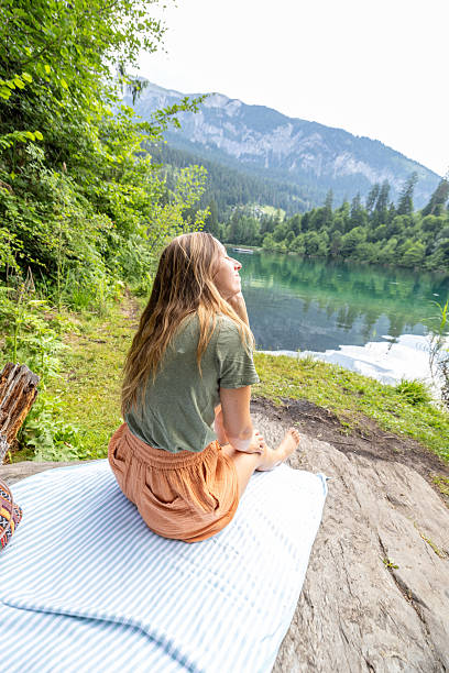 istock Woman Relaxing by Scenic Mountain Lake 2221812556