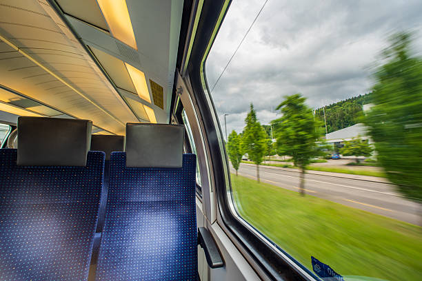 istock Empty blue cloth seats inside passenger train in Europe. Large window side seats, moving train, blurred exterior rural  background, no people 2221812588