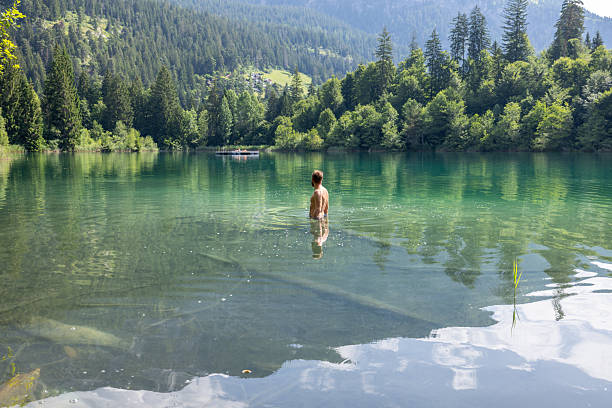 istock Man Wading in Tranquil Mountain Lake 2221812869