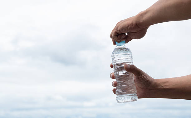 istock Person opening a plastic bottle of water 2221812884