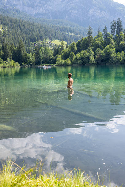 istock Man Wading in Tranquil Mountain Lake 2221812899