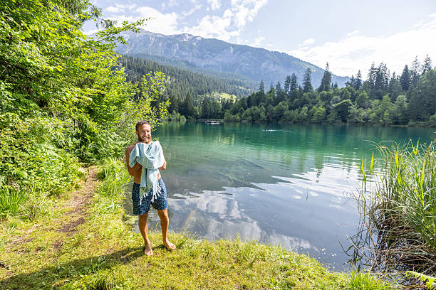 istock Man Enjoying a Refreshing Swim by a Scenic Mountain Lake 2221812998