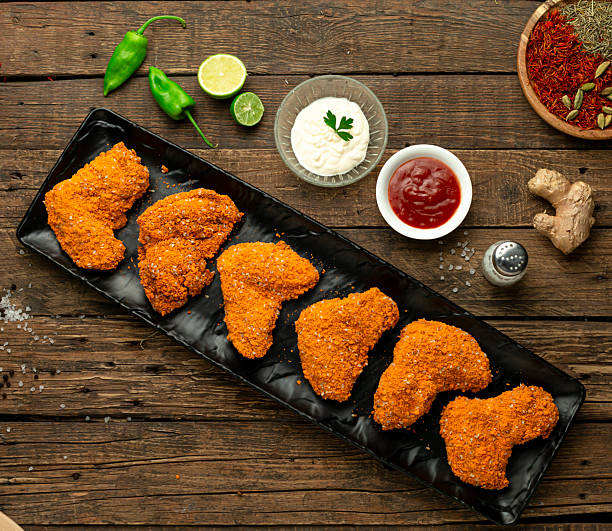 Raw crispy chicken wings with sauce, top view.