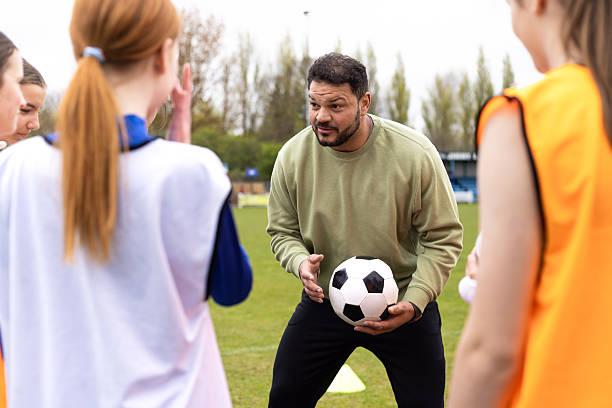 istock Football Team Learning and Preparing with Coach 2221815057