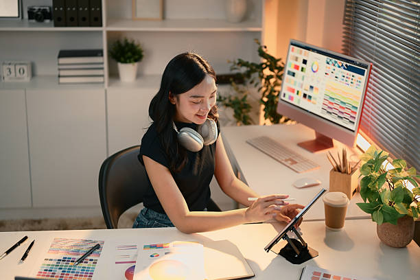 istock Smiling young graphic designer using digital tablet in a creative office with color palettes 2221816574