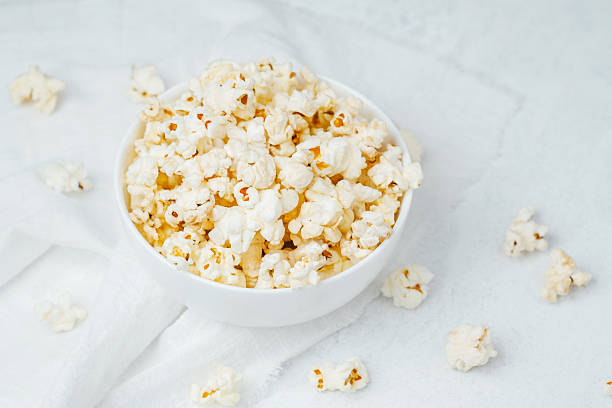 istock Freshly popped popcorn in a white bowl on a light background 2221819461