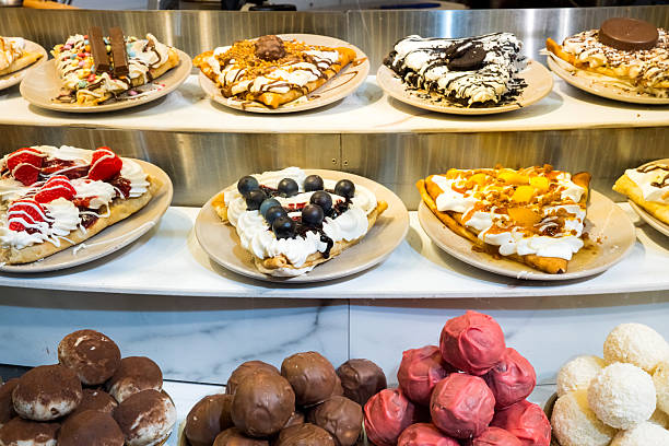 Assorted gourmet waffles with diverse toppings displayed on plates in bakery setting.