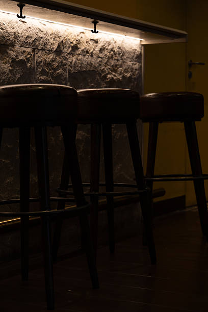 istock Moody Interior of Empty Bar with Dimly Lit High Stools 2221825161