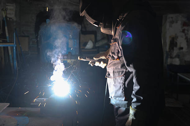 istock Industrial worker welding metal and producing sparks in workshop 2221825486