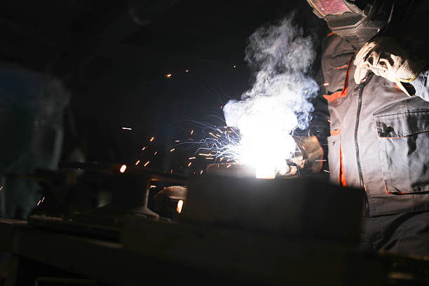 istock Industrial worker welding metal and producing sparks in workshop 2221825707
