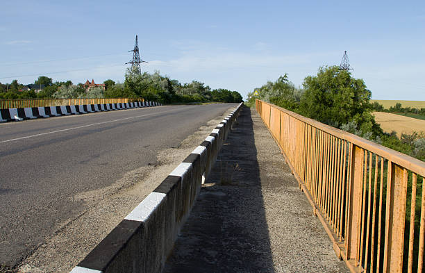 A road with a fence and trees. Outdoor. Sky. Ground. Way. Traveling