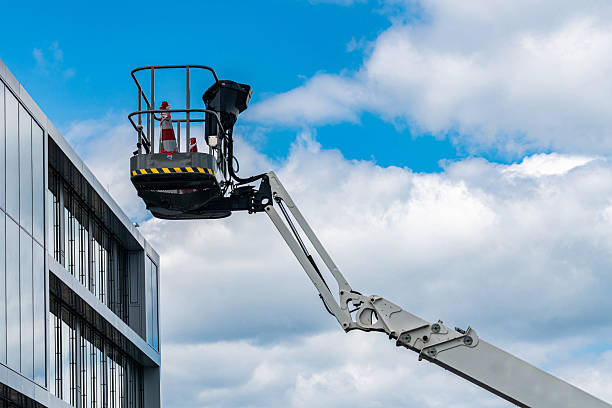 istock Folding hydraulic crane with steel cabin next to a building. 2221830330