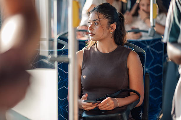 istock Young woman holding smartphone while riding public transport 2221831069