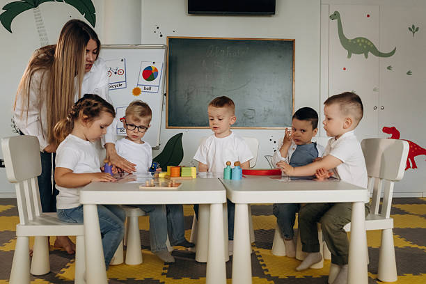 istock Educational games. Children in kindergarten with their teacher 2221831103