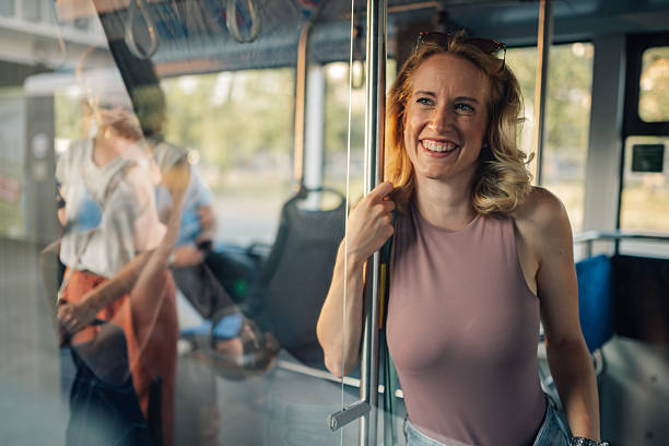 istock Young woman smiling while riding public transportation bus 2221831345