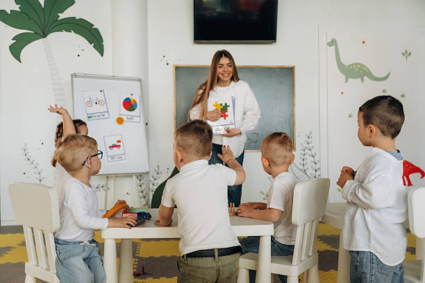 istock Having fun by learning. Children in kindergarten with their teacher 2221831488