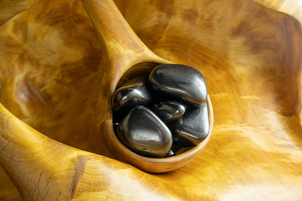 istock Wooden bowl filled with black stones 2221831959