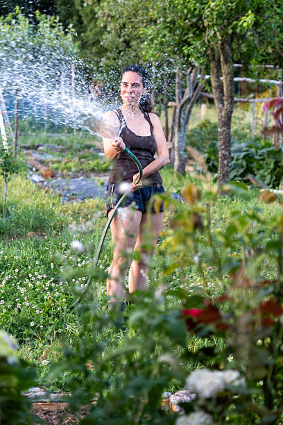 istock Woman Watering Plants 2221832578
