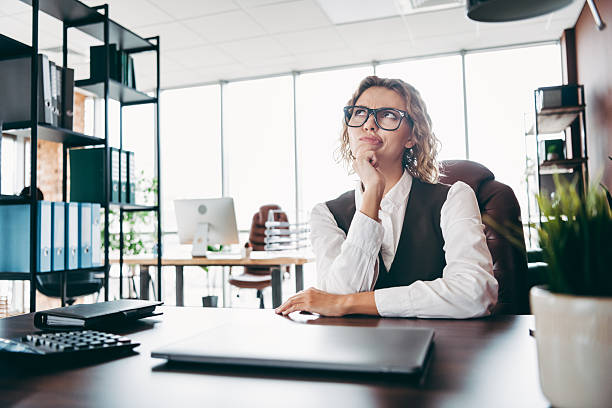 istock Confident businesswoman contemplating ideas in a modern office workspace with bright light and professional setup 2221834419