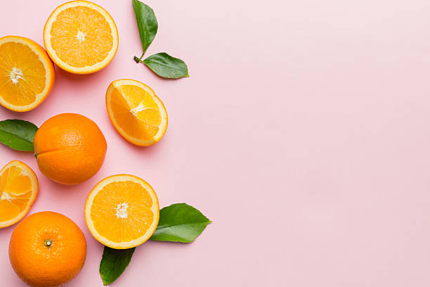 istock fresh Fruit orange slices on colored background. Top view. Copy Space. creative summer concept. Half of citrus in minimal flat lay with copy space 2221834769