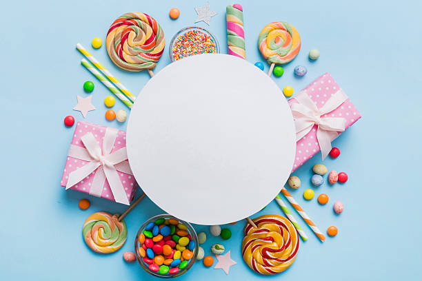 istock Flat lay holiday composition. Paper blank, lollipop, birthday decorations on Colored background. Top view, copy space for text 2221834881