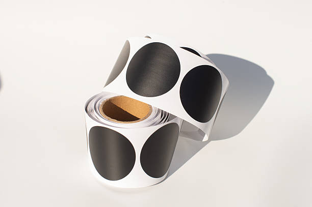 Roll of black circular stickers on a white background