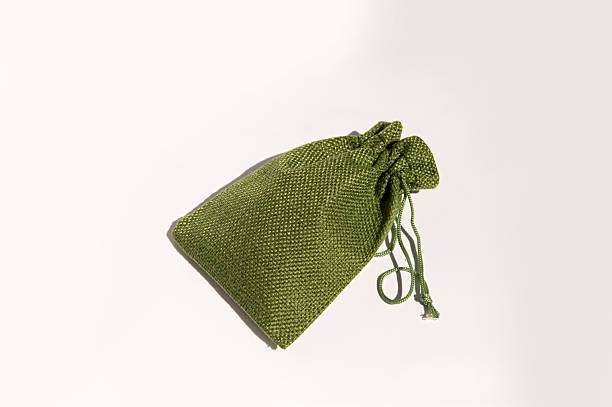 Green fabric drawstring bag on white background: elegant textured storage pouch.