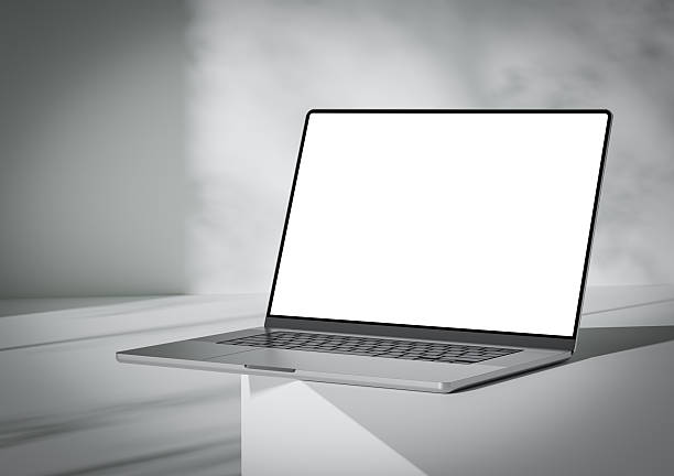 A laptop with a blank screen stands on the corner of a box-like surface