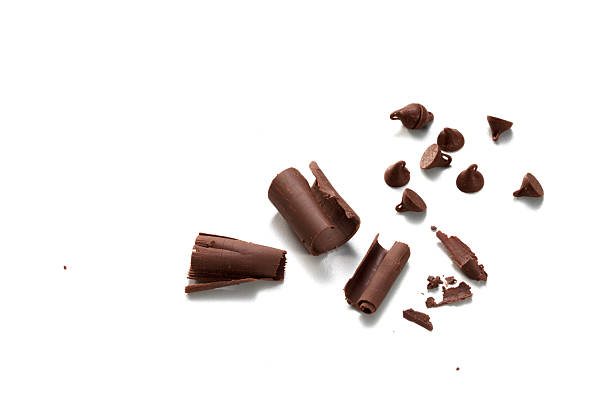istock Chocolate chips curls scattered isolated on white background. Brown choco cocoa food ingredient 2221837591