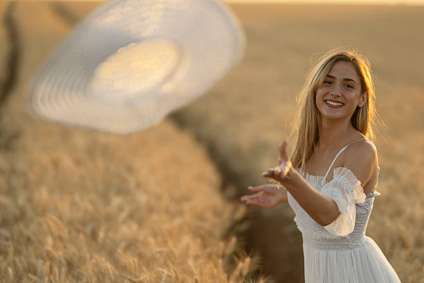 Beautiful hippie woman on hay bale in field