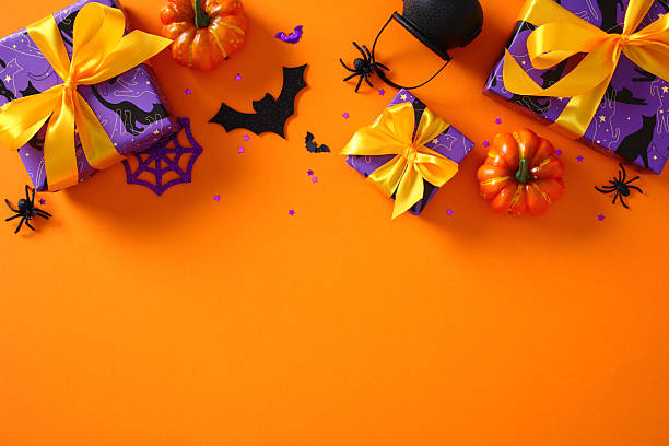 istock Creative Halloween layout: gift boxes, spiders, bats, and pumpkins on bright orange background. Flat lay, top view. 2221840328