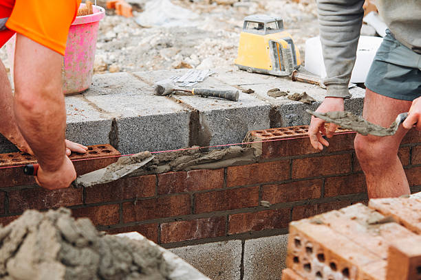 istock Close-up of Skilled bricklayer laying bricks with trowel on construction site 2221842129