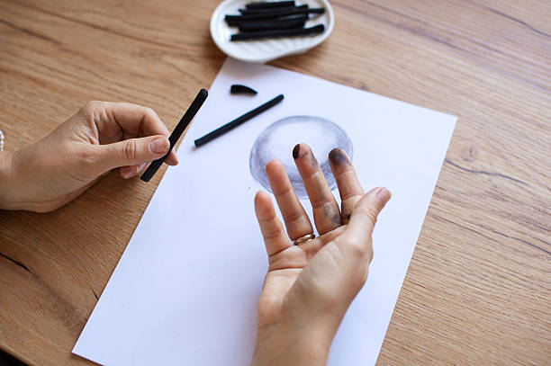 istock Artist's Hand with Charcoal Sticks Drawing on Paper 2221842228