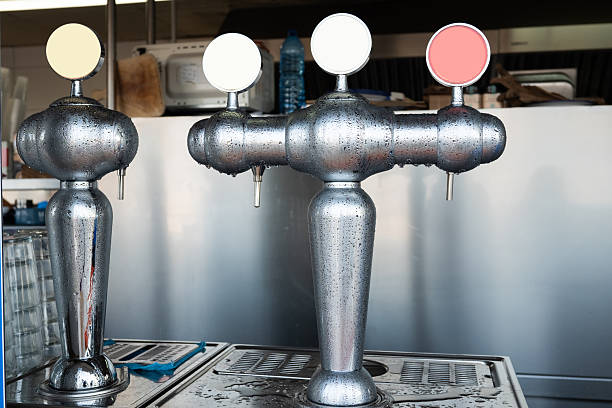 Bar tap dispensers with three different color handles in a refreshment facility.