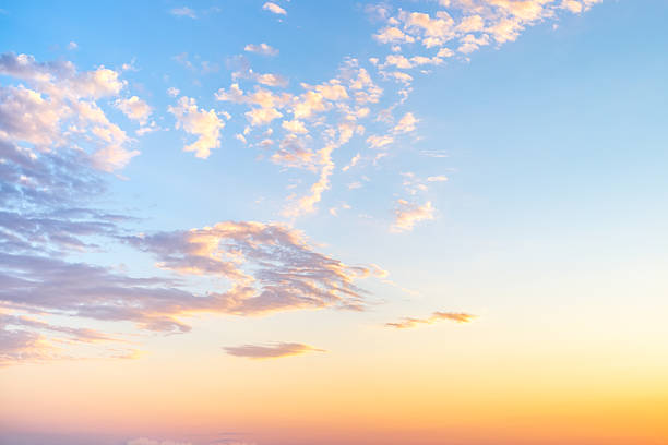 istock sky with wispy cirrus clouds illuminated by the setting sun in soft orange tones. Celestial landscape 2221845395