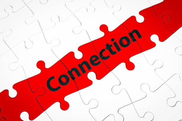 A white jigsaw puzzle with a red jigsaw puzzle connecting the center. Concept of networking, and filling in gaps to connect efficiently.