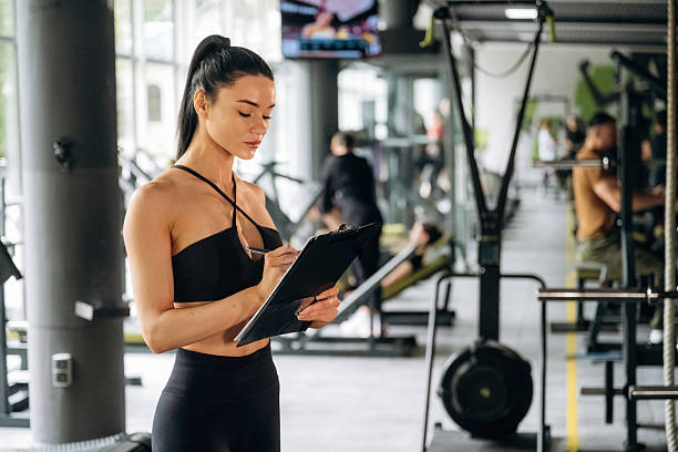 istock With notepad. Female trainer is standing in the gym 2221853419