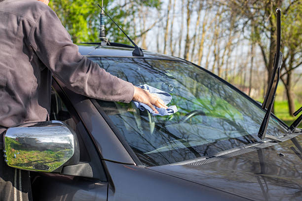 istock man with rag washing car windshield against trees background 2221855417