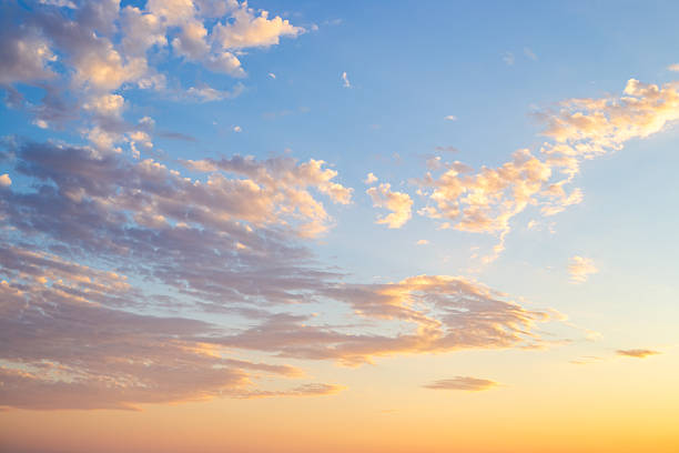 istock A panoramic photo of the sky with thin cirrus clouds illuminated by the setting sun in soft orange tones 2221855418