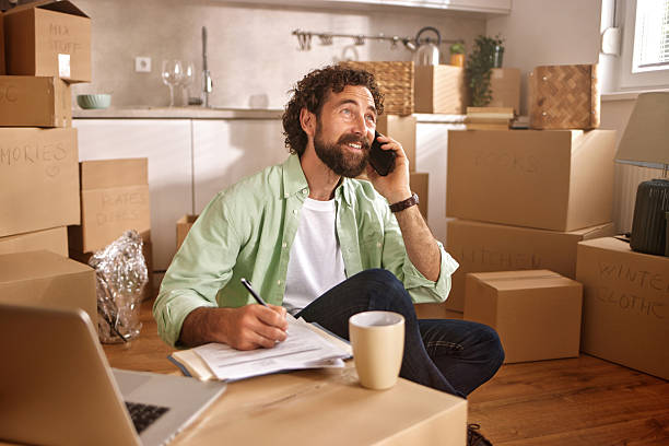 istock Man organizing moving to new home and making a phone call 2221855488