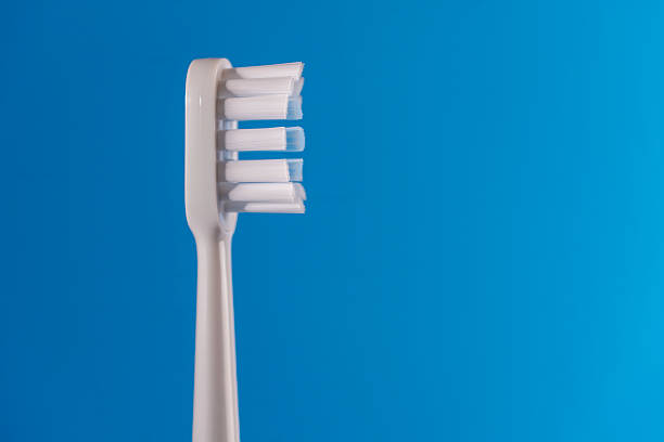 istock White new plastic toothbrush on blue background, closeup, copy space 2221861061