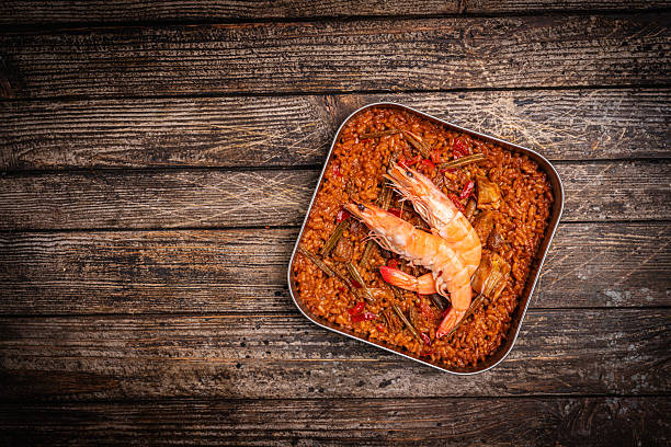 Experience culinary harmony as golden-fried shrimp rejoins the vibrant medley of flavors in the traditional Spanish paella, enriching each bite with savory delight