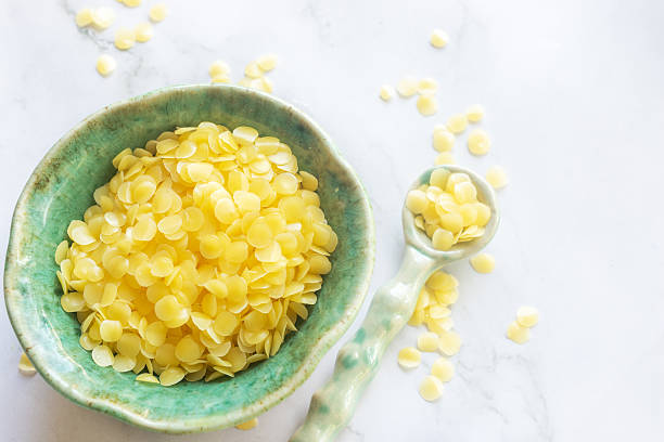 istock natural beeswax pellets in ceramic bowl on white marble background. 2221863578