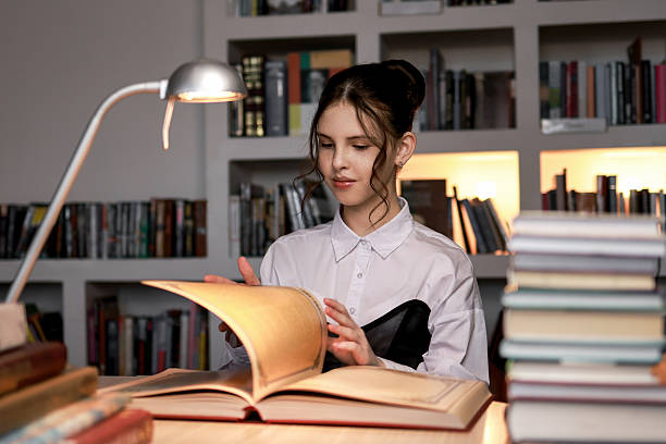 istock A girl reads a huge historical book in an atmospheric setting. 2221863670