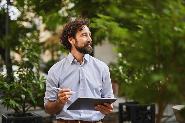 Businessman working with digital tablet outdoors, embracing modern technology