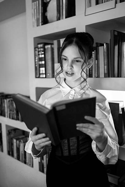 istock A girl in the library with a book. 2221863943