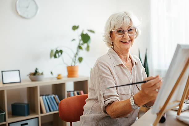 istock Senior woman posing for camera while painting at home 2221864441